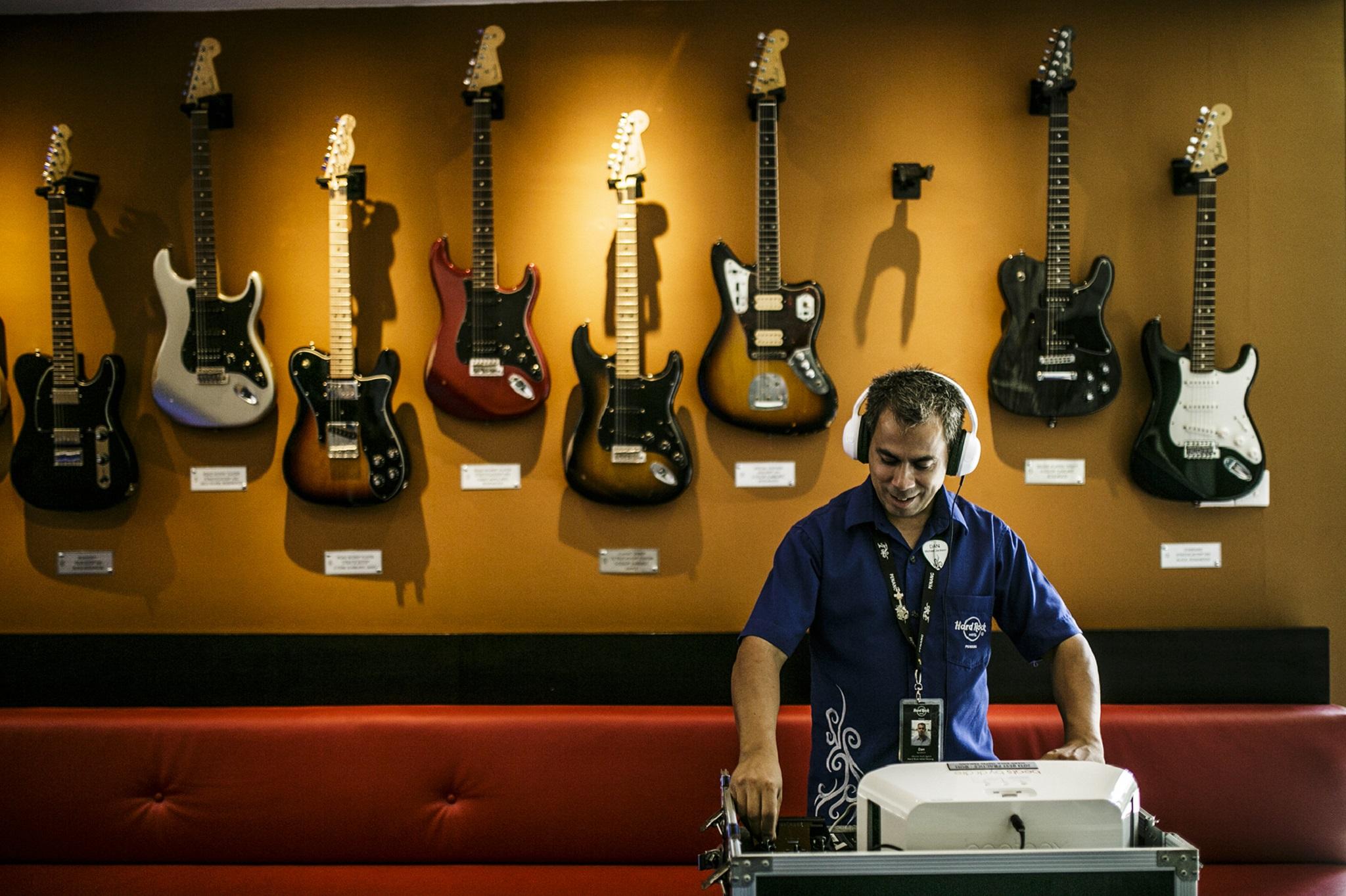 Hard Rock Hotel Penang Batu Ferringhi Exterior foto A guitar store employee listens to a customer's selection